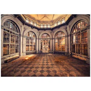 een lege kamer met veel ramen en een geblokte vloer