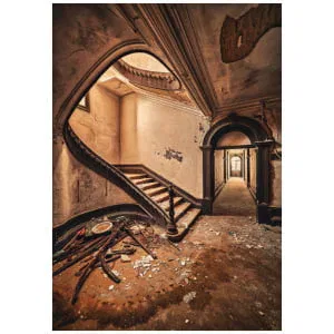 een verlaten gebouw met een trap en kapotte ramen