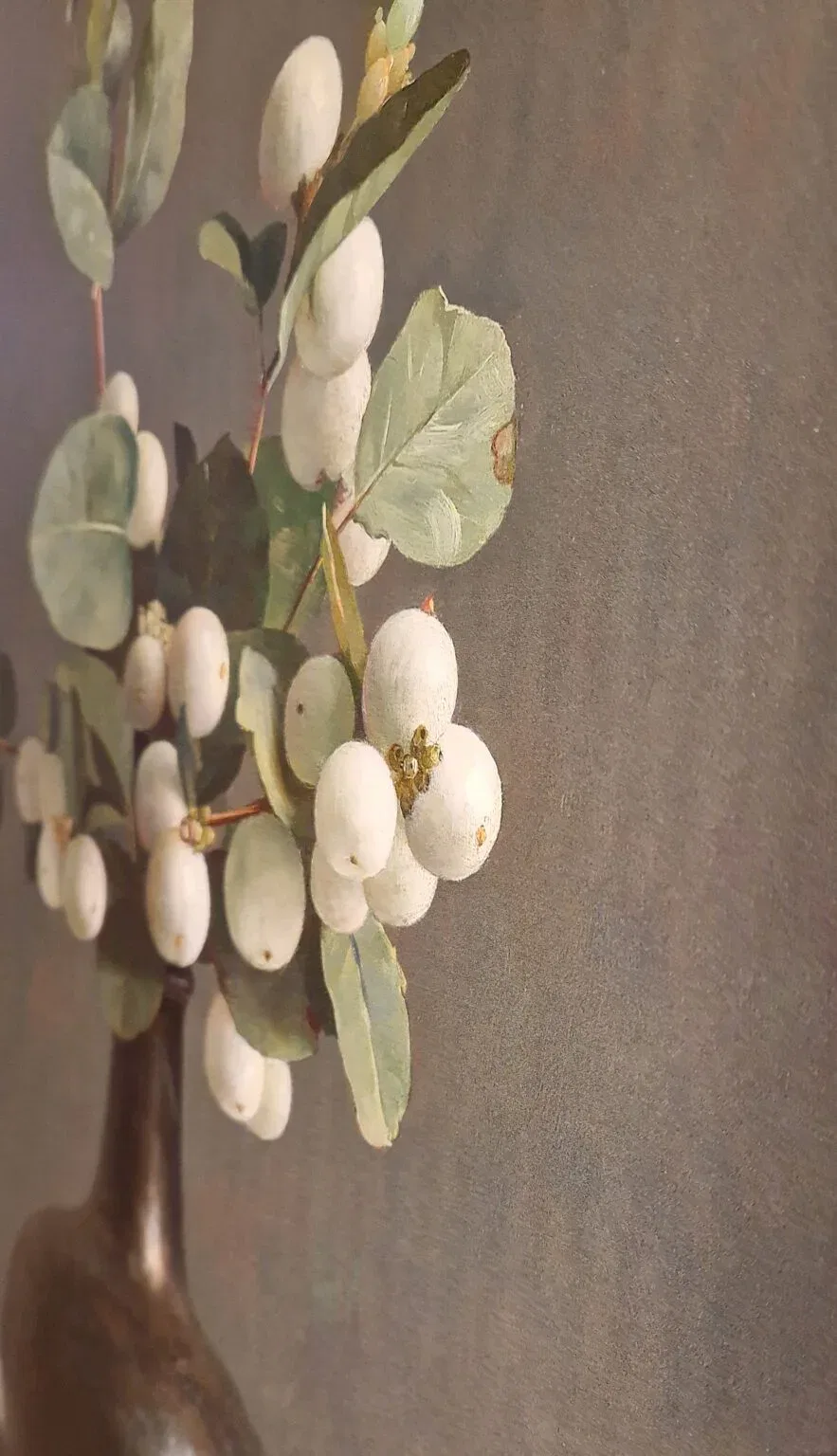 een vaas gevuld met witte bloemen en groene bladeren