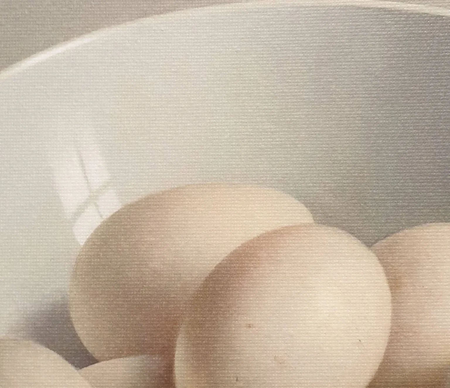 een witte kom gevuld met eieren op een tafel