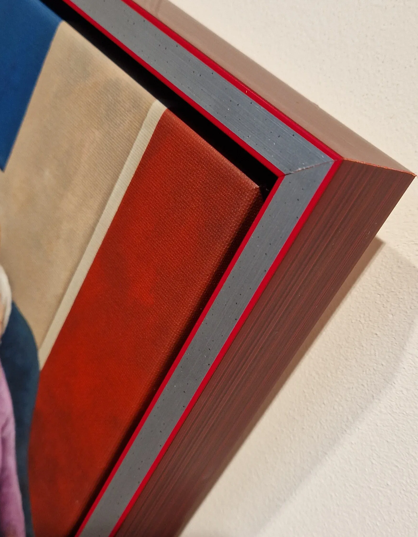 een kleine teddybeer die voor een schilderij zit