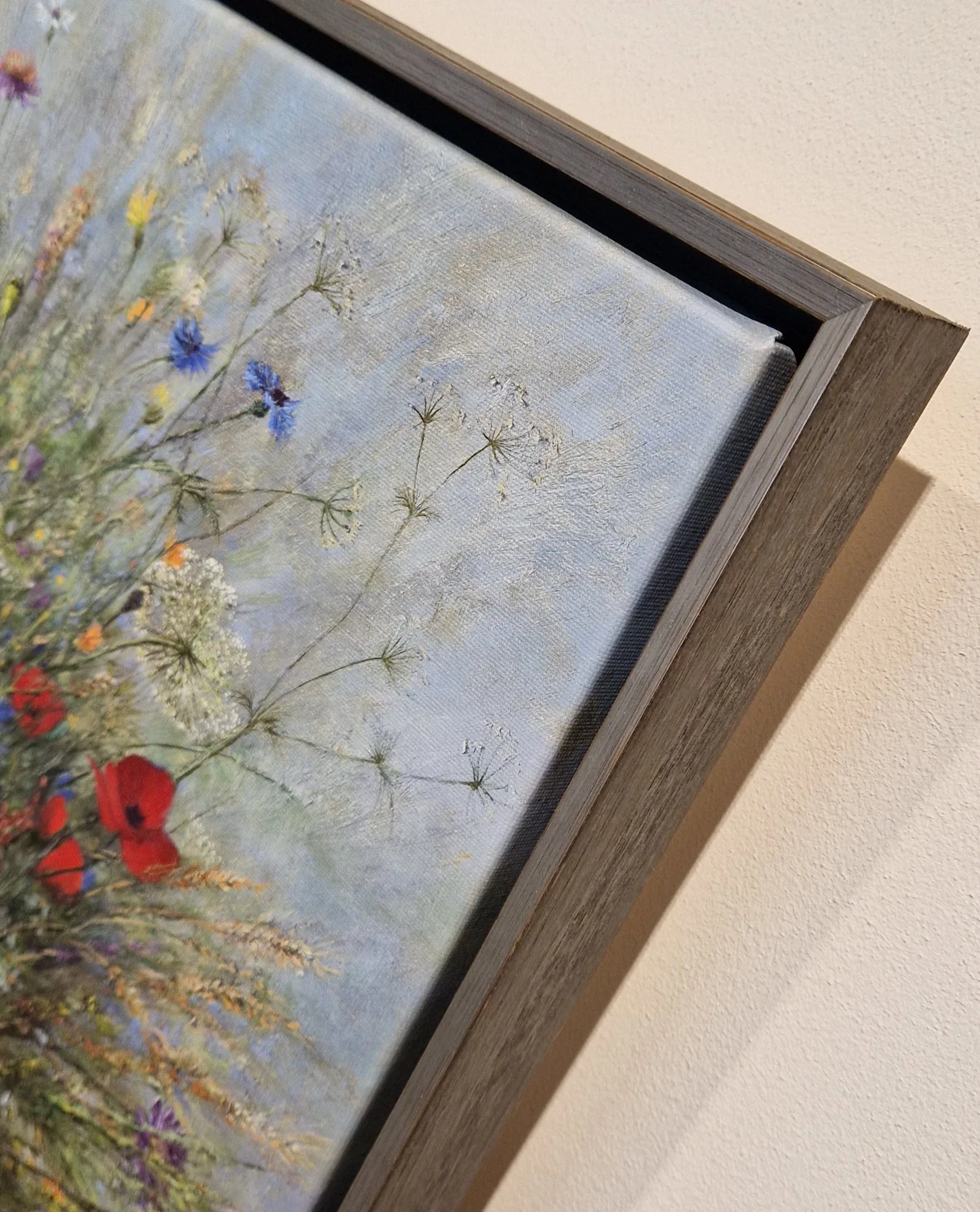 een schilderij aan de muur met bloemen erin