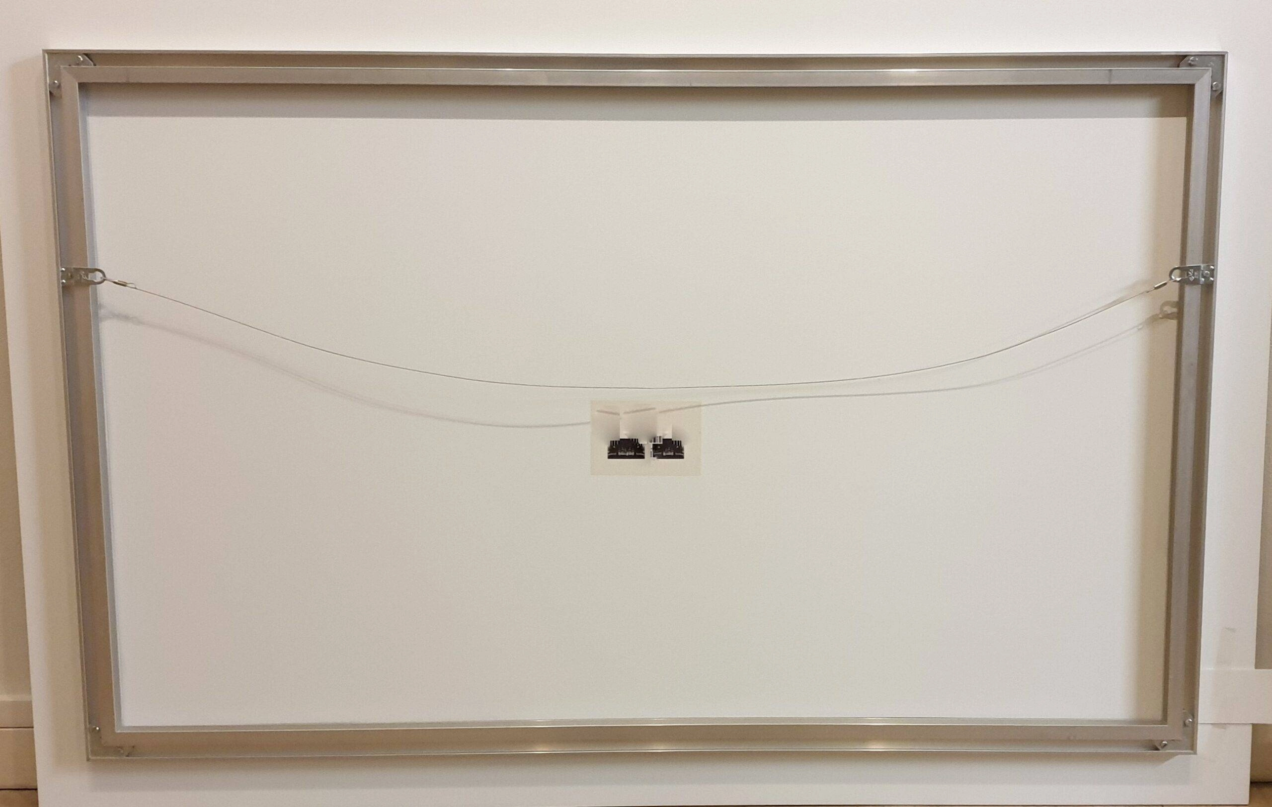 een witte muur met twee kleine elektrische draden eraan vastgemaakt