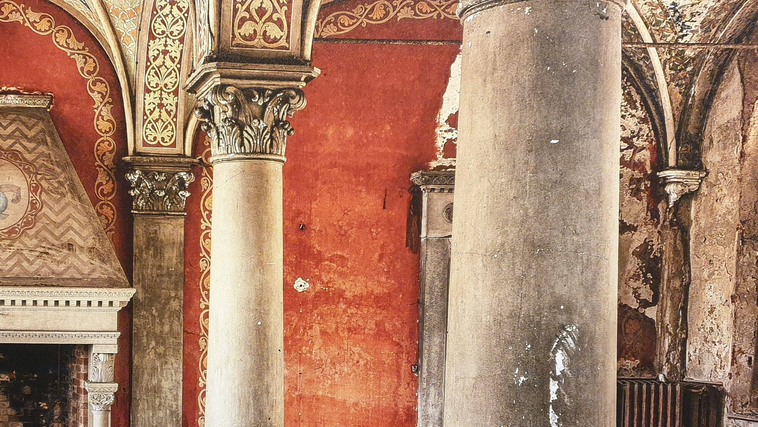 een oud gebouw met kolommen en een klok aan de muur