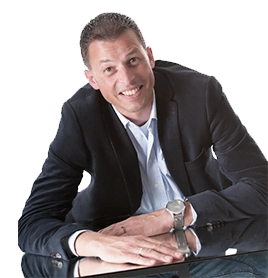 een man in pak en stropdas, zittend aan een tafel