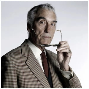 een man in een pak die een lepel voor zijn mond houdt