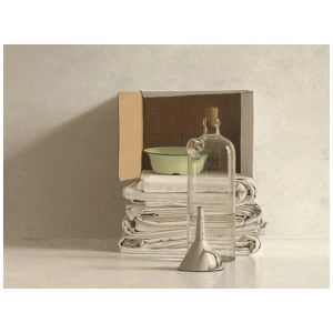 een stapel papieren en een fles op een tafel