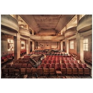 een verlaten zaal met rode stoelen en kapotte piano