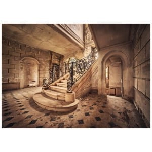 een trap in een oud gebouw met zwart-wit geblokte vloeren