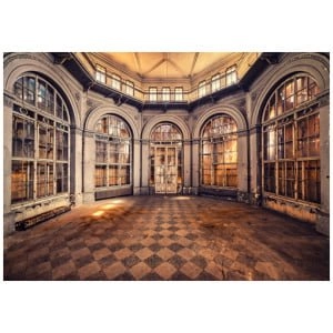 een lege kamer met veel ramen en een geblokte vloer