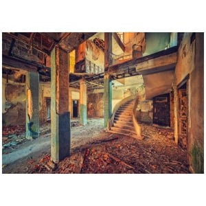 een verlaten gebouw met een trap naar de tweede verdieping