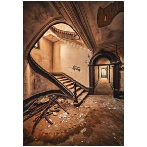 een verlaten gebouw met een trap en kapotte ramen