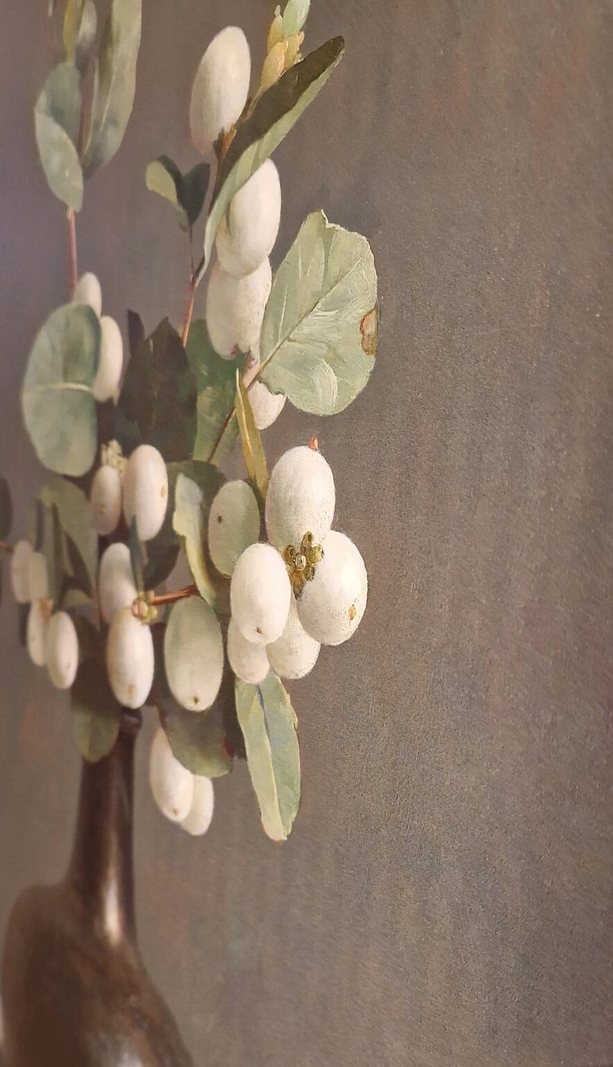 een vaas gevuld met witte bloemen en groene bladeren