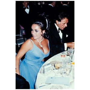 een vrouw in een blauwe jurk, zittend aan een tafel